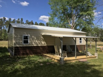 Metal Hunting Cabin | Boxed Eave Roof | 24W x 36L x 9H | Lean-to Porch